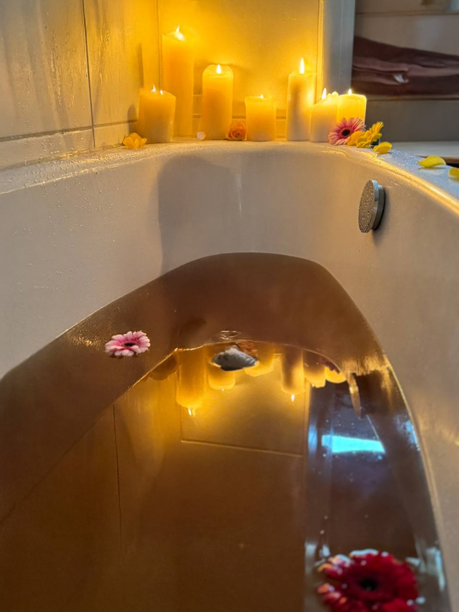 Ein wohltuendes Bad mit duftenden Blüten und beruhigendem Licht hilft dir, die Geburt loszulassen und in die neue Phase einzutauchen.